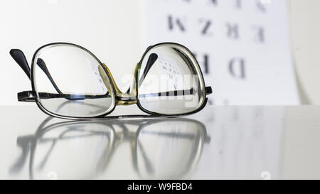 Old glasses on a table in a white room. Stock Photo