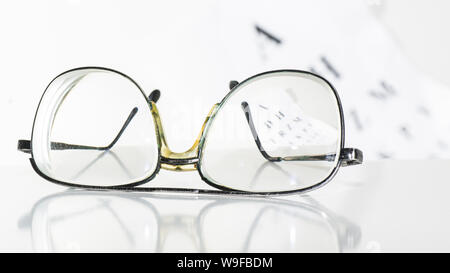 Old glasses on a table in a white room. Stock Photo