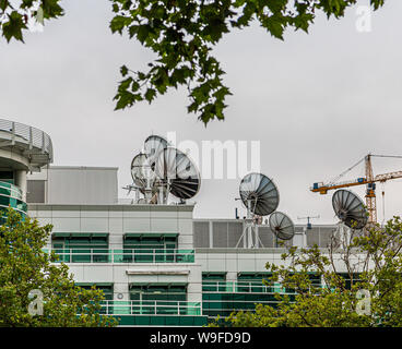 Many Satellite Dishes on Rooftop of a Communicaitons Building Stock Photo