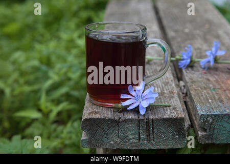 cup of chicory drink on on edge of wooden old background in the garden. Rustic still life Stock Photo