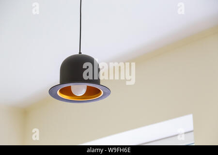 Modern black hanging lamp in shape of hat Stock Photo