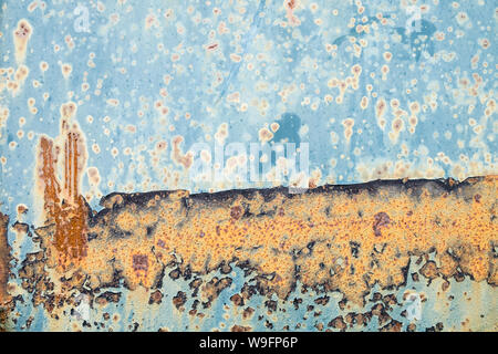 A textural abstract of orange rust on blue metal. Stock Photo