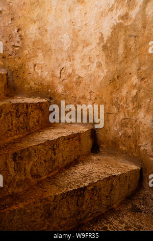 A rustic spiral staircase going up in shades of ochre and rust, part of an old Venetian lighthouse in Fiskardo, Kefalonia. Stock Photo