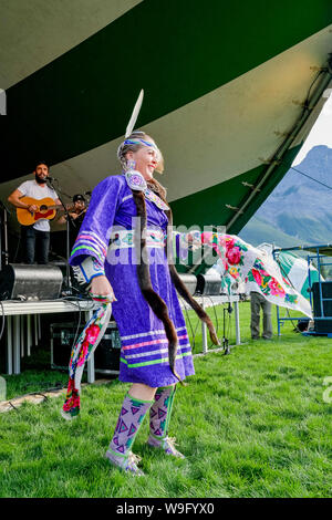 Female Indigenous dancer, dances while Michael Bernard Fitzgerald plays on stage, Canmore Folk Music Festival, Canmore, Alberta, Canada Stock Photo