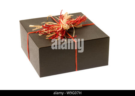 A gift wrapped in plain red paper with a raffia bow isolated on a white  background Stock Photo - Alamy