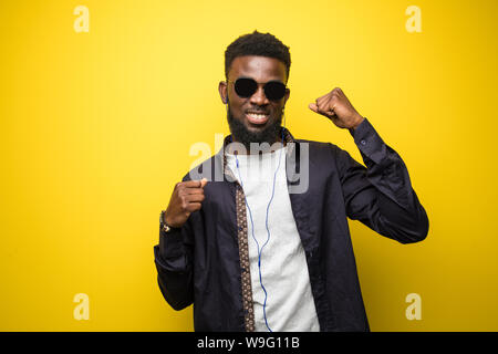 Young african american man on vibrant yellow background celebrating a victory Stock Photo