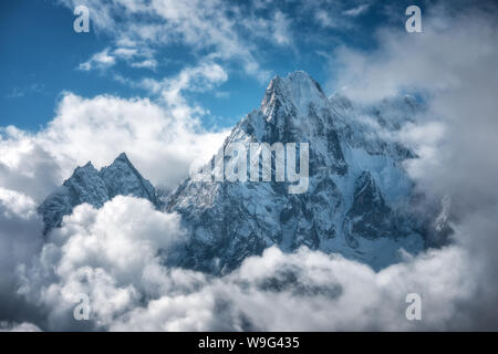 Manaslu mountain with snowy peak in clouds in sunny bright day Stock Photo