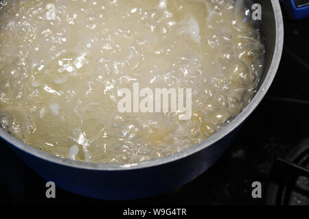 Boiling pasta in blue pot on cooker Stock Photo