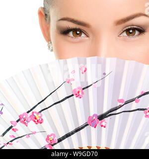 Closeup portrait of young woman with folding fan. Mixed race Asian / Caucasian female is with brown eyes. She is isolated over white background. Stock Photo