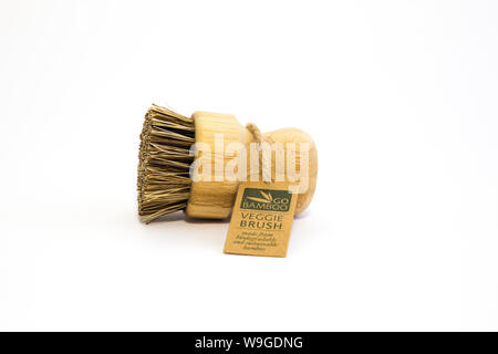 Go Bamboo branded veggie brush with bass fibres, twine tag. Biodegradable materials. Isolated on white background Sustainability concept. Low waste. Stock Photo