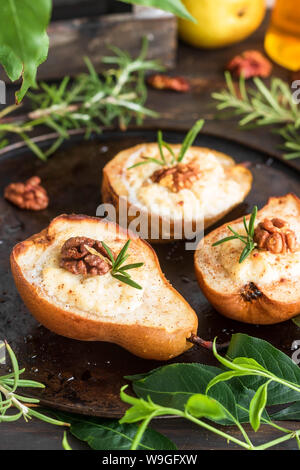 Baked pears with ricotta, walnuts and honey. Light healthy dessert without sugar. A warming dish. Stock Photo