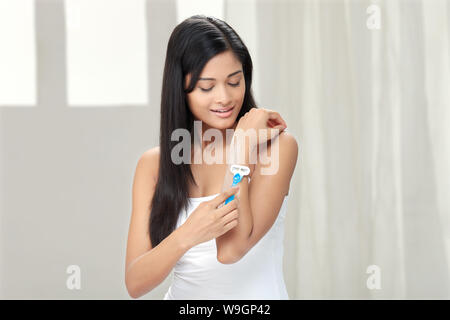 Young woman shaving her forearm Stock Photo