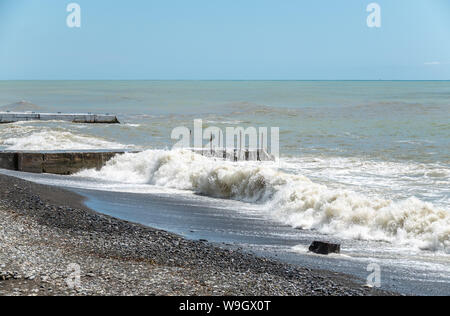 Sea wave with spray during storm at Black sea in Sochi, Russia. Muddy sea waves with foam and spray. Stock Photo