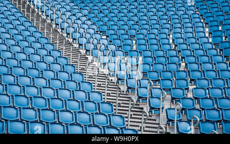 Blue plastic empty stadium or stage chairs in a row Stock Photo