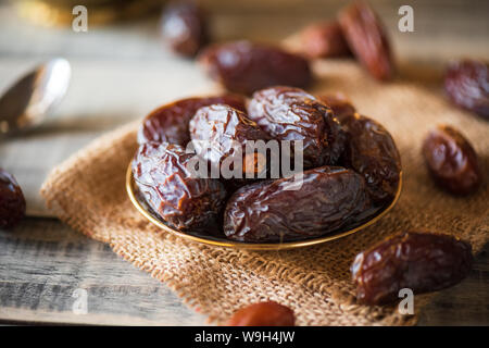 Ramadan food and drinks concept. Dates fruit in a bowl on wooden table background. Stock Photo