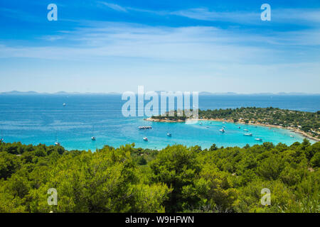 Panoramic view on Kosirina beach lagoon on Murter island in Croatia, anchored sailing boats and yachts on blue sea Stock Photo