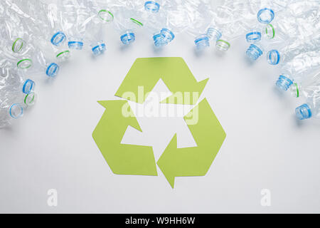 Frame of used plastic bottles with recycling symbol on wooden background. Recycle concept