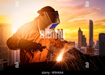 Industrial worker welding steel structure for infrastructure building project. photo concept for Construction industry and engineering work. Stock Photo