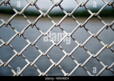 Mesh cage fence with wire behind, marine concept. Stock Photo