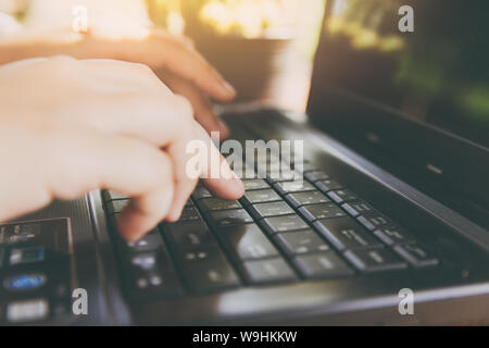 closeup hand typing on laptop computer for working day vintage color tone Stock Photo