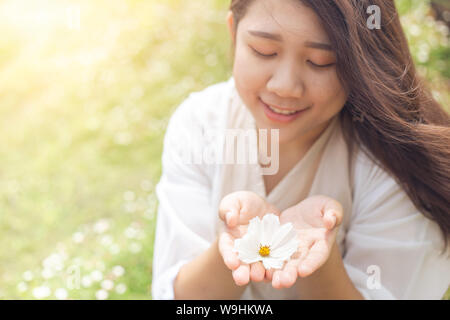 Cute beautiful Asian healthy plump plus size girl teen with flower outdoor happy smile Stock Photo