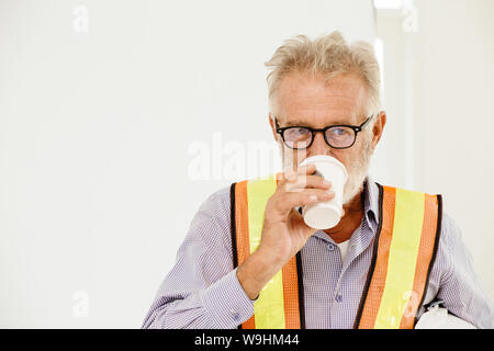professional senior home builder engineer or foreman drinking hot coffee Stock Photo