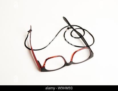 Stylish red eyeglasses with black cord on white background Stock Photo