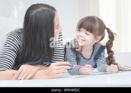 Happy loving family mother and her daughter child girl play in children room. Funny mom and lovely child having fun together. Stock Photo