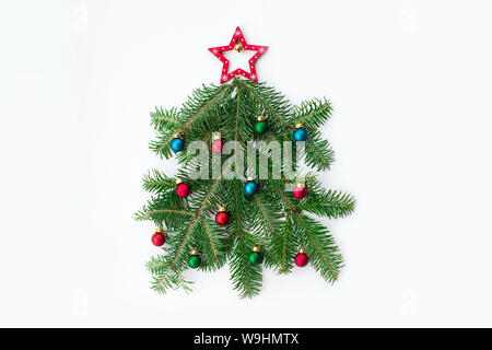 Stylized Christmas clock made of fir-tree branch and red ball toys on marble background. New Year and Christmas celebration concept. Flat lay, top vie Stock Photo