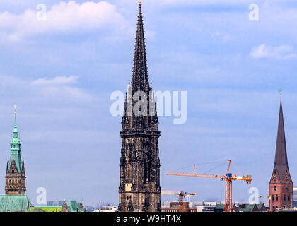 Hamburg, Germany -The ruin of the memorial church St. Nikolai. City Hall on the left, St. Petri Church on the right. Stock Photo