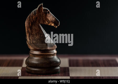 black chess knight alone on the chessboard, black background and copyspace Stock Photo