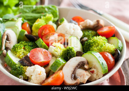 Flavorful Italian salad with marinated vegetables, mushrooms, cherry tomatoes and Parmesan on wooden background Stock Photo