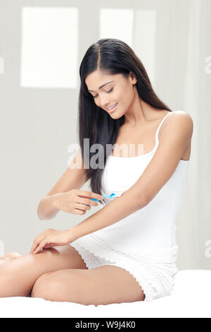 Young woman shaving her forearm Stock Photo