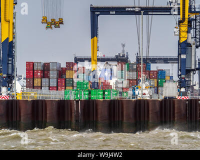 Shipping containers site dockside at Felixstowe port as strong winds delay loading and unloading of containers. Stock Photo