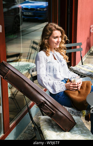 Young violinst on cafe terrace drinking coffee Stock Photo