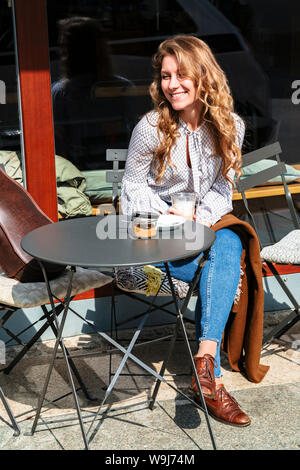 Girl violinist sitting on coffee break in cafe Stock Photo