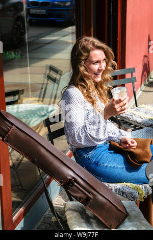 Girl violinist sitting on coffee break in cafe Stock Photo