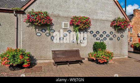 ALNESS ROSS AND CROMARTY SCOTLAND VILLAGE TOWN IN BLOOM  A WALL OF HANGING BASKETS AND TROPHY PLAQUES Stock Photo