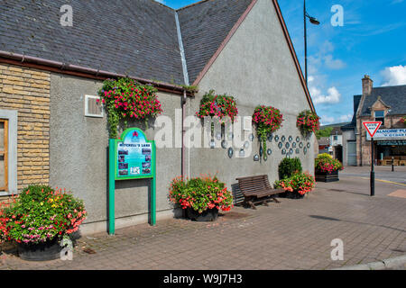 ALNESS ROSS AND CROMARTY SCOTLAND VILLAGE TOWN IN BLOOM  A WALL OF HANGING BASKETS AND WINNING TROPHY PLAQUES Stock Photo