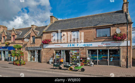 ALNESS ROSS AND CROMARTY SCOTLAND VILLAGE TOWN IN BLOOM SHOPS AND  COLOURFUL FLOWERS IN HANGING BASKETS AND CONTAINERS Stock Photo