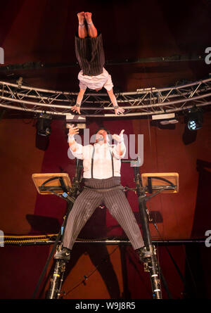 Edinburgh, Scotland, UK, 14 August 2019. Edinburgh Festival Fringe. The Fringe’s newest Guinness World record holders at Underbelly Circus Hub Spiegeltent transformed into Hotel Paradiso’s drawing room featuring Lost in Translation circus performers Roisin Morris and Massimiliano Rossetti who broke the Guinness World Record for most somersaults on a Korean Cradle on 10 August with 16 full somersaults and catches on the cradle, the only one in regular use in UK. Pictured with other Hotel Paradiso cast members Stock Photo