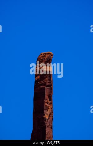 Vertical shot of a tall rock with clear blue sky in the background Stock Photo