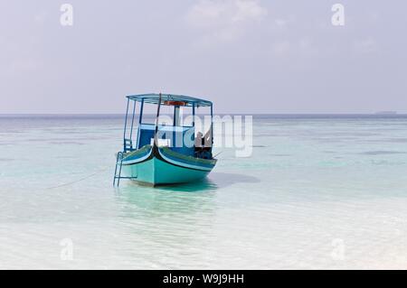 Ari Atoll, Maldives - 25 December 2018: A maldivian sailor is fishing on his blue boat called 'dhoni' Stock Photo