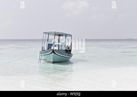 Ari Atoll, Maldives - 25 December 2018: A maldivian sailor is fishing on his blue boat called 'dhoni' Stock Photo