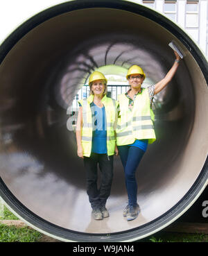 Berlin, Germany. 14th Aug, 2019. Ronny Richter, site manager, and Marina Boldt, project manager, (l-r) are standing in a pipe for the new combined sewer. A 129 year old sewage pumping station in Charlottenburg is replaced by a new building. Credit: Annette Riedl/dpa/Alamy Live News Stock Photo