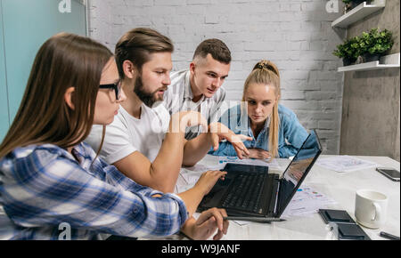 Office teamwork in action: senior colleague instructing coworkers Stock Photo