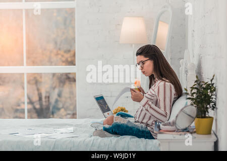 Attentive longhaired brunette sitting in semi position Stock Photo