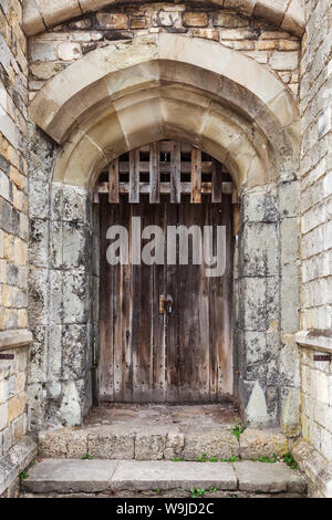 Locked wooden door in old fortification wall, background photo texture Stock Photo