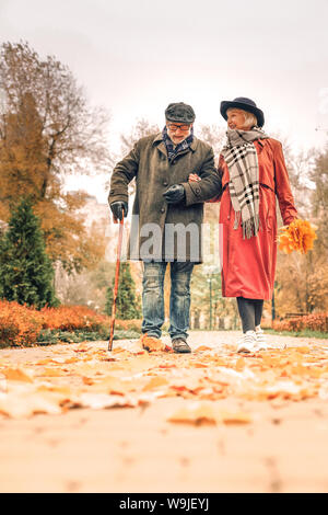 Elderly husband and wife strolling down the park Stock Photo