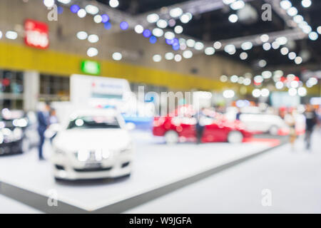 Abstract blurred image of cars exhibition show. Blurred defocused image of public event exhibition hall showing cars and automobiles, business commerc Stock Photo